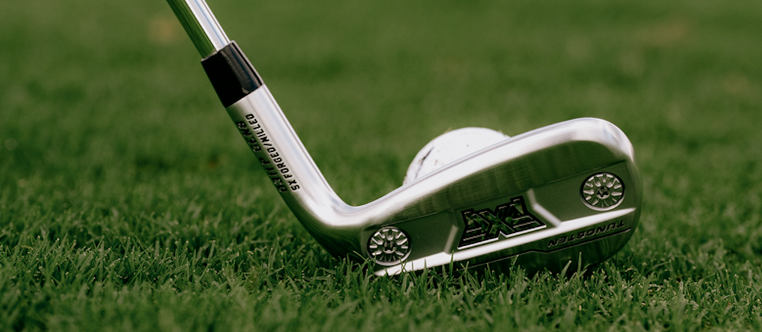 0311 PXG GEN8 Irons on grass with a golf ball.