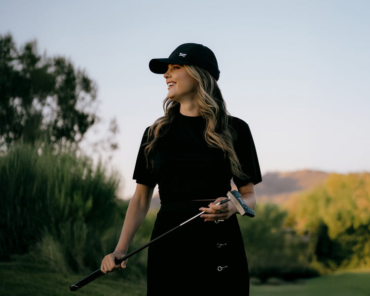 woman wearing pxg apparel and holding a putter