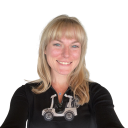 A smiling blonde woman with blue eyes wearing a black long-sleeve top with a white and gray golf cart graphic on the front, set against a plain white background.