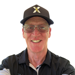 A smiling man wearing a black baseball cap with a gold and white 'X' logo, clear-framed glasses, and a black polo shirt, photographed against a plain white background.