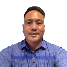 A man wearing a blue patterned button-down shirt, photographed against a plain white background.