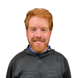 A smiling man with red hair and a beard wearing a black athletic hoodie with a gray logo, isolated on a white background.