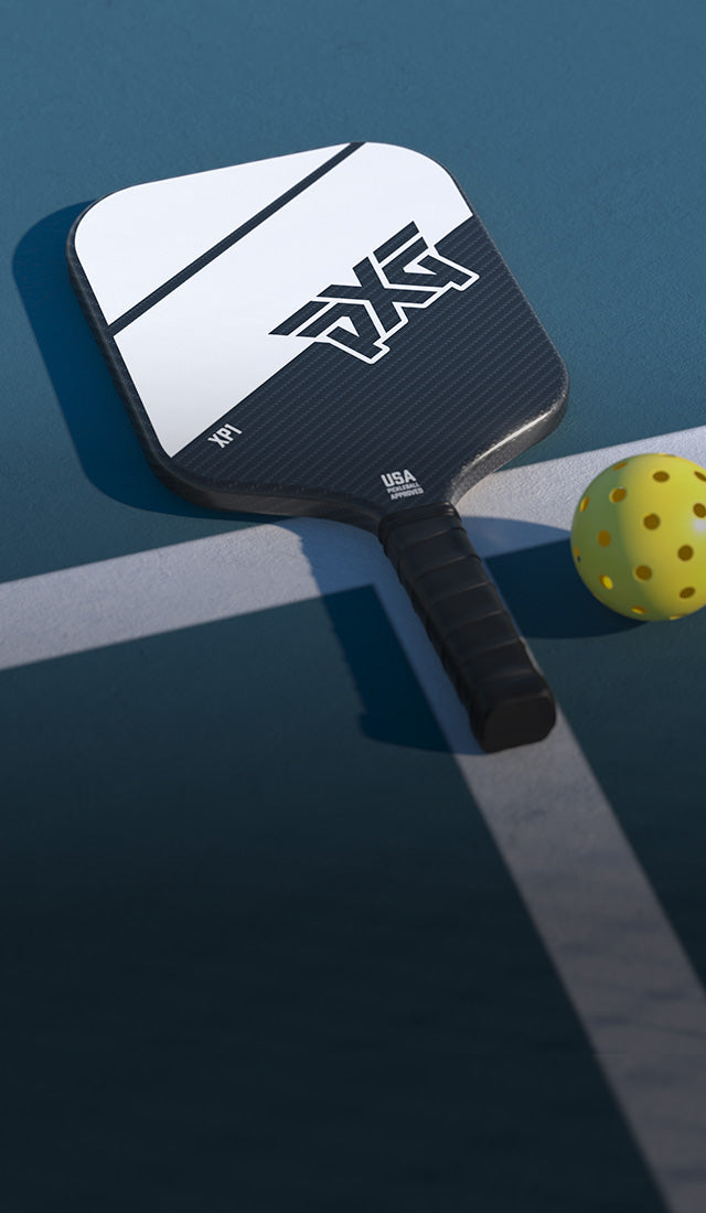 Pickleball paddle and ball on a court with AXS branding