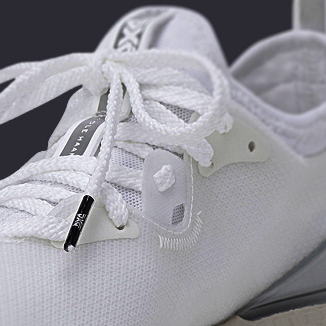 Close-up of a white sneaker with laces and brand logo.