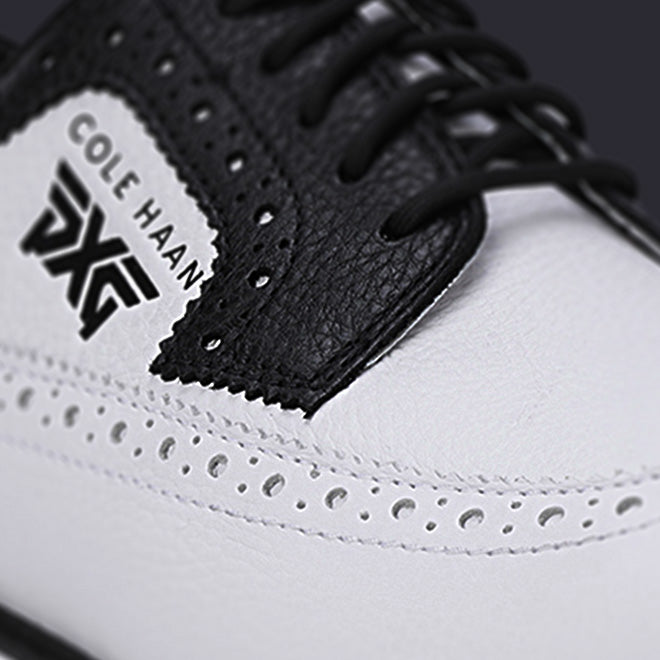 Close-up of a Cole Haan sneaker with white toe box and black leather details.