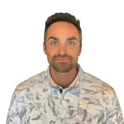 A man with short brown hair and a light beard wearing a light gray and white camouflage zip-up jacket with a gold logo on the left chest, photographed against a solid white background.