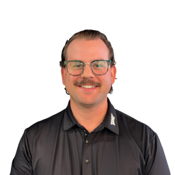 A smiling man with glasses and a mustache wearing a black button-down shirt, shown from the chest up against a plain white background.