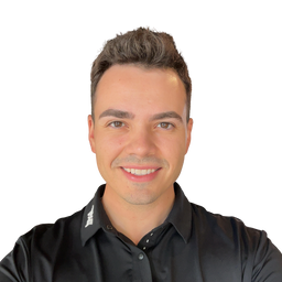 A smiling man with short brown hair wearing a black button-up shirt, photographed against a plain white background.