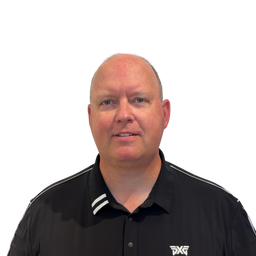 A man with a shaved head wearing a black short-sleeve collared shirt with white stripes on the collar and a white logo on the left chest, set against a plain white background.