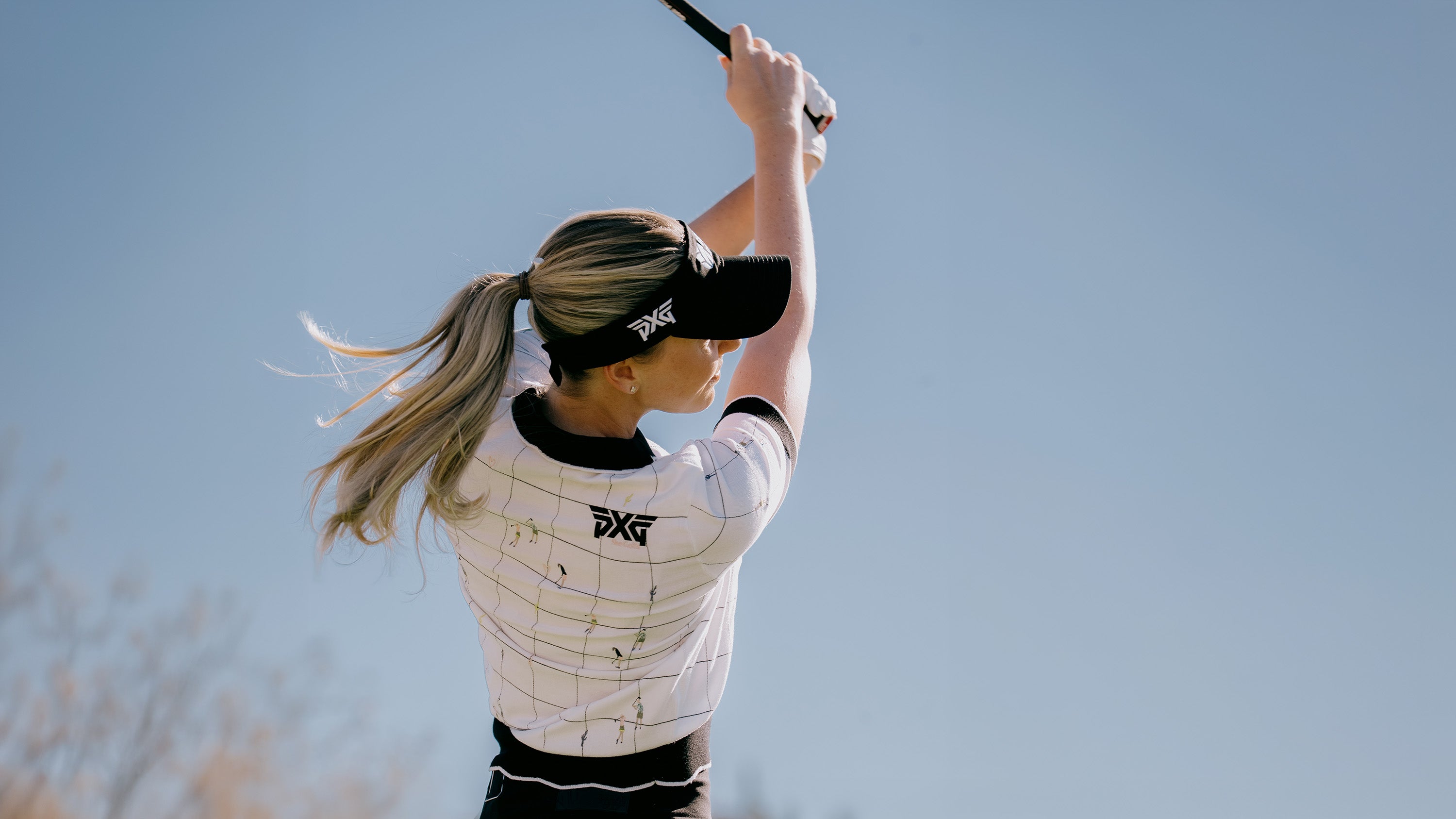 Person playing golf with a clear blue sky in the background