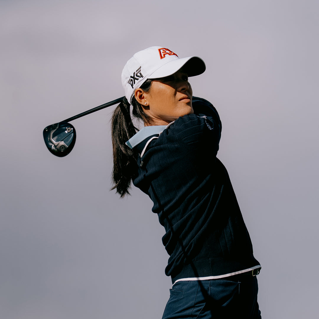 LPGA Tour Pro Celine Boutier wearing PXG Golf Hat against a blue gray sky