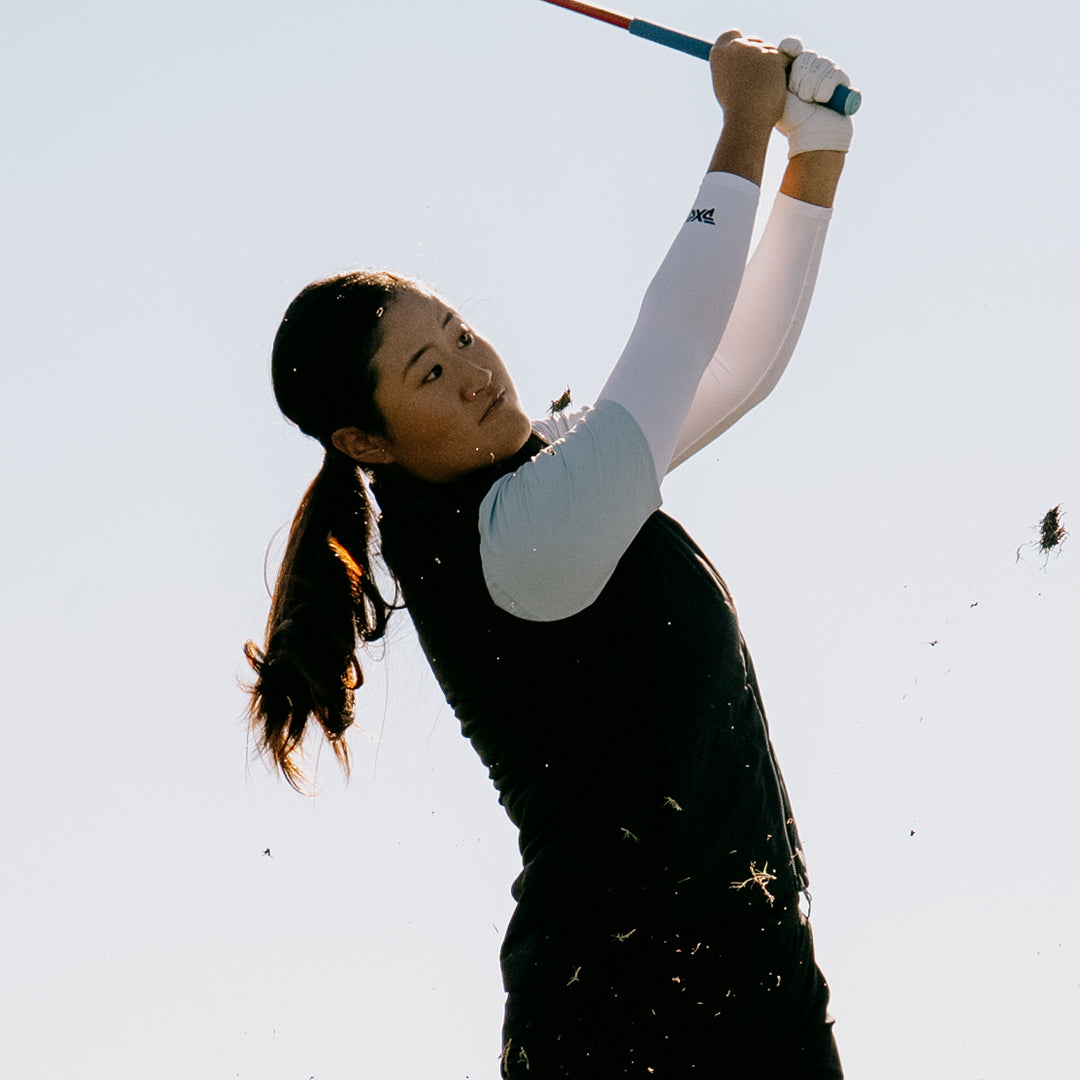 LPGA Tour Pro Gina Kim swinging a golf club against a white sky