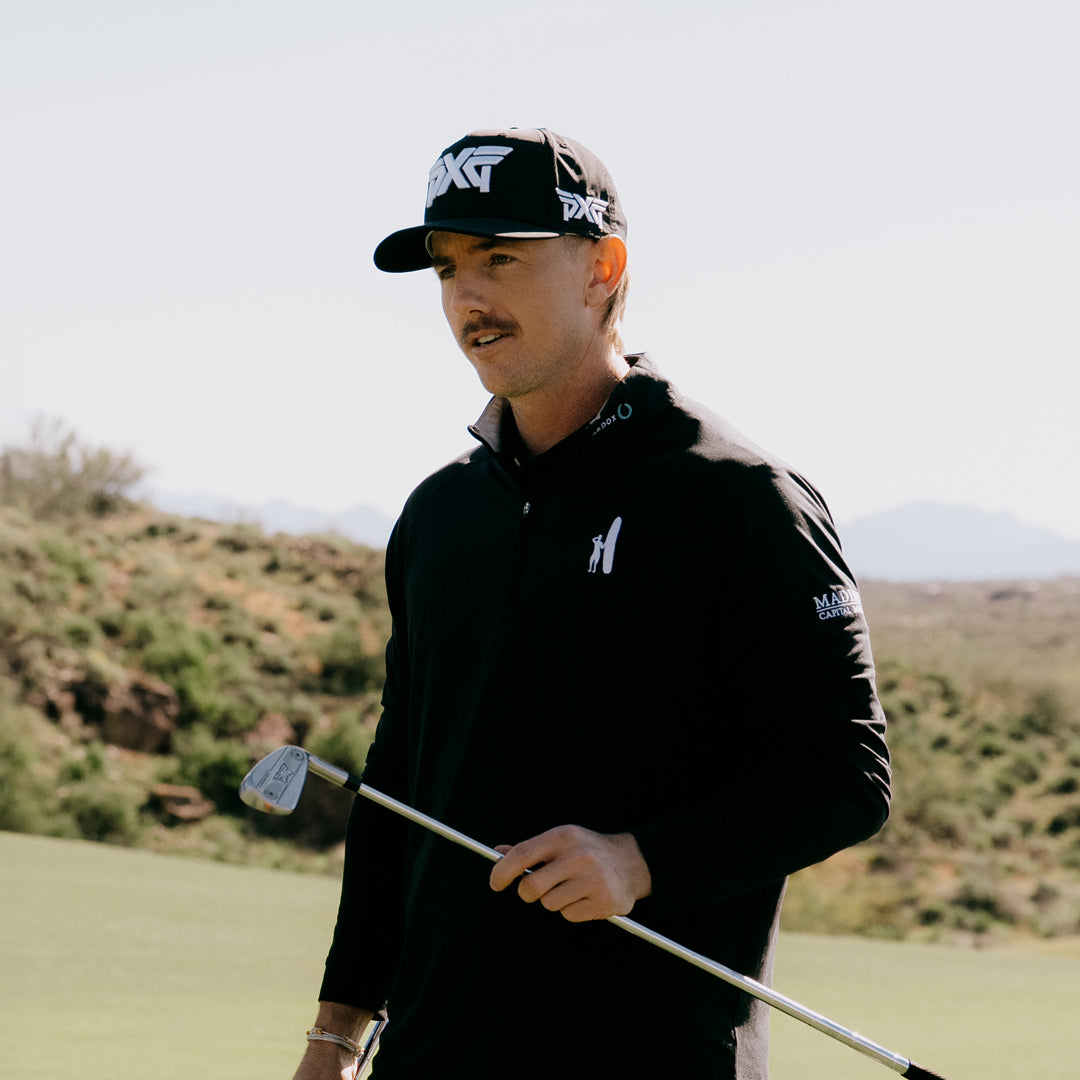 PGA Tour Pro Jake Knapp wearing PXG Golf Hat on a golf course holding a golf club.