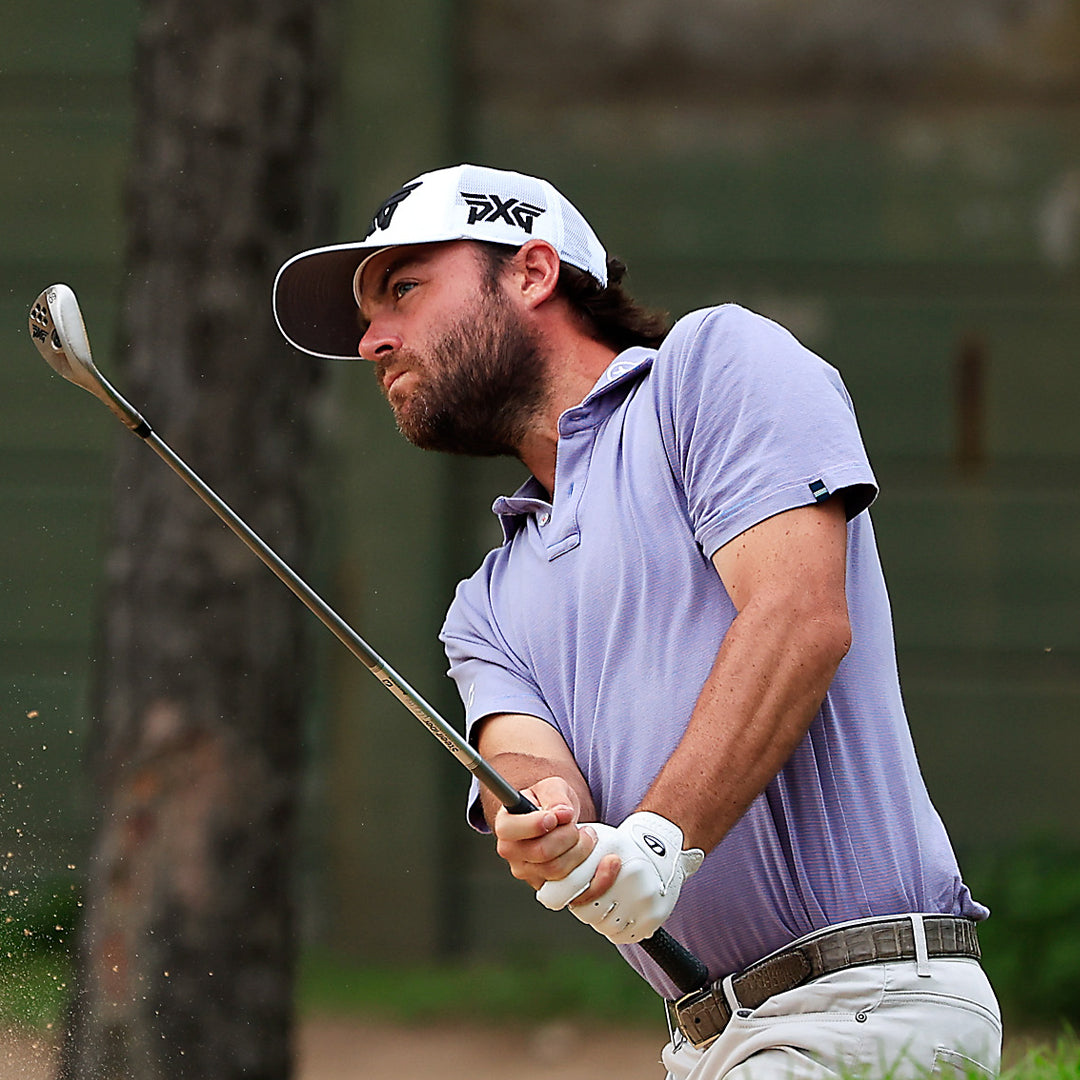 Tour Pro Joey Garber wearing a PXG hat swinging a golf club on a golf course.