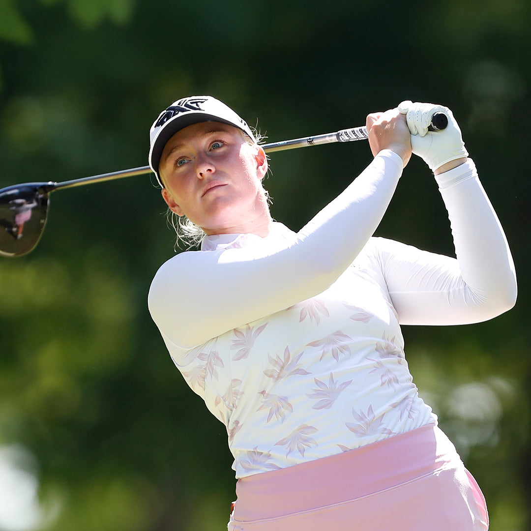 Development Tour Pro Kaitlin Milligan wearing a PXG hat swinging a golf club on a golf course.