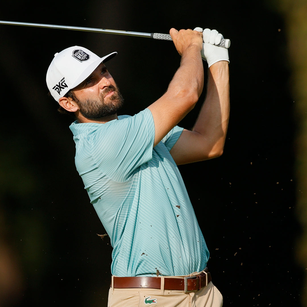 Tour Pro Paul Barjon wearing a PXG hat swinging a golf club on a golf course.