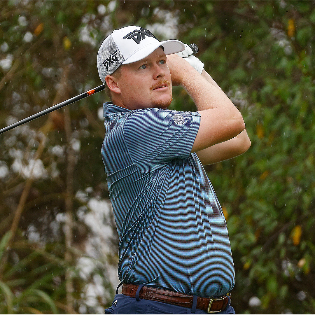Tour Pro Shad Tuten wearing a PXG hat swinging a golf club on a golf course.