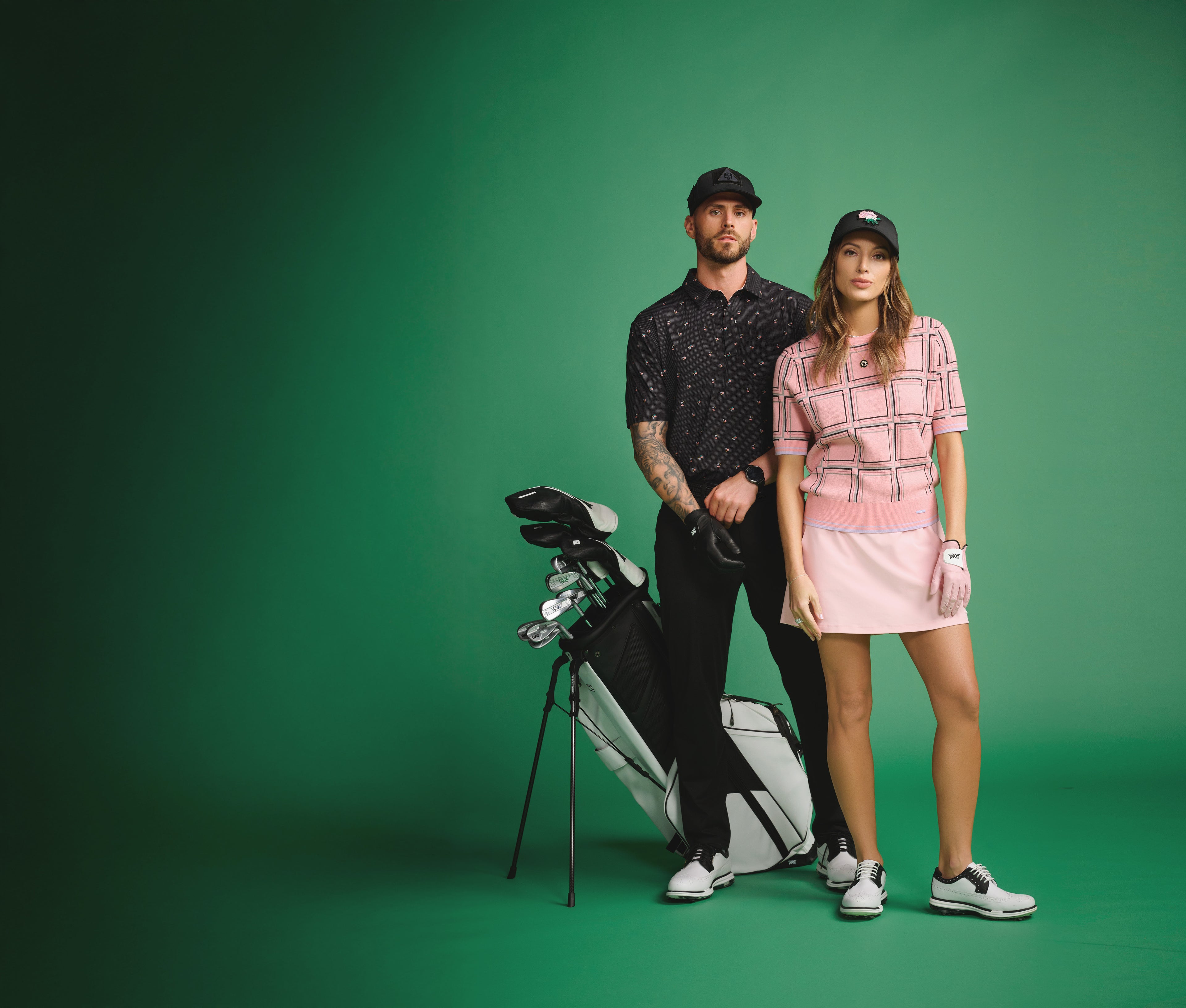 Two people standing with golf equipment on a green background