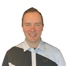 A smiling man with short brown hair wearing a black, white, and light blue color-blocked polo shirt with a small dark logo on the left chest, set against a plain white background.