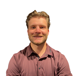 A smiling man with blond hair and a light beard wearing a dusty rose button-up shirt, isolated on a solid white background.