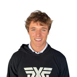 A smiling young man with light brown hair wearing a black hoodie with a white graphic logo on the chest, layered over a light blue collared shirt, against a plain white background.