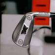 Close-up of a golf club head with a blurred background
