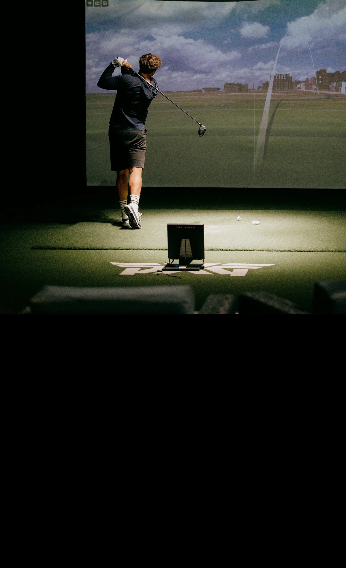 Person playing golf simulator game on a screen