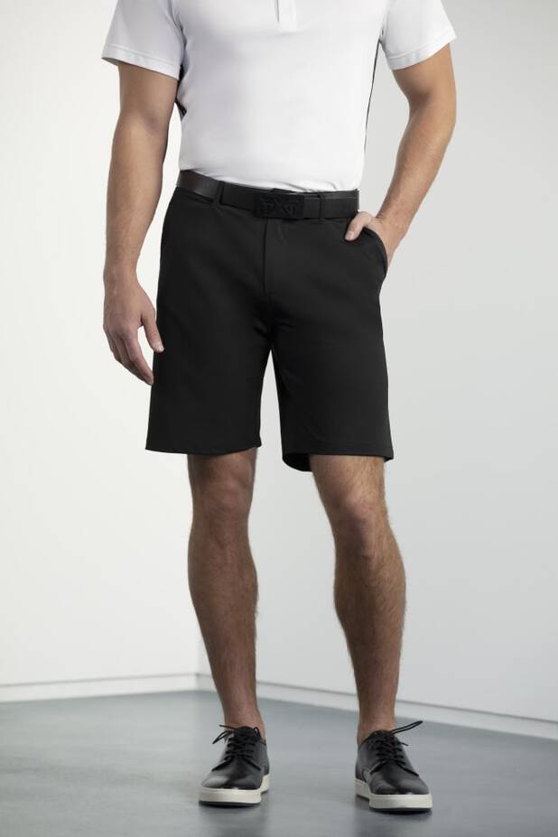 Model wearing black shorts and white polo